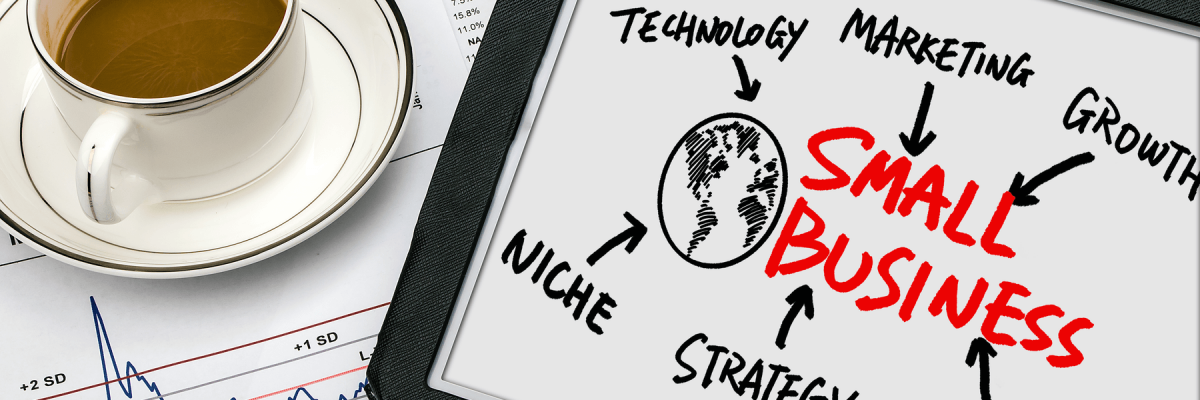 Small business concept. Diagram hand drawing on tablet, coffee cup, and graph on table.