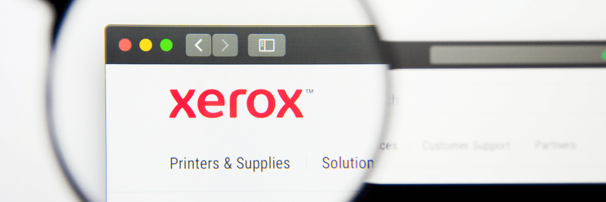  Xerox website homepage. Xerox logo visible on display screen being magnified by magnifying glass