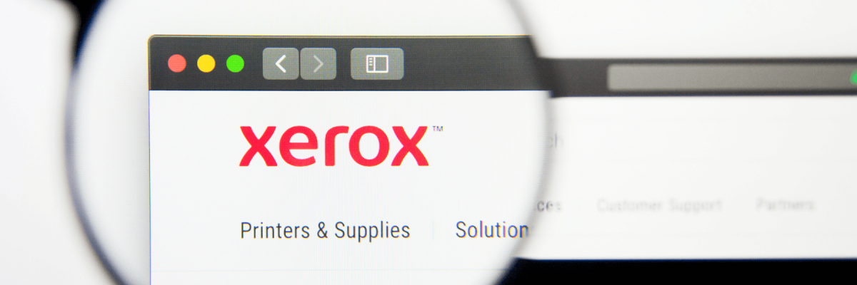 Xerox website homepage. Xerox logo visible on display screen being magnified by magnifying glass
